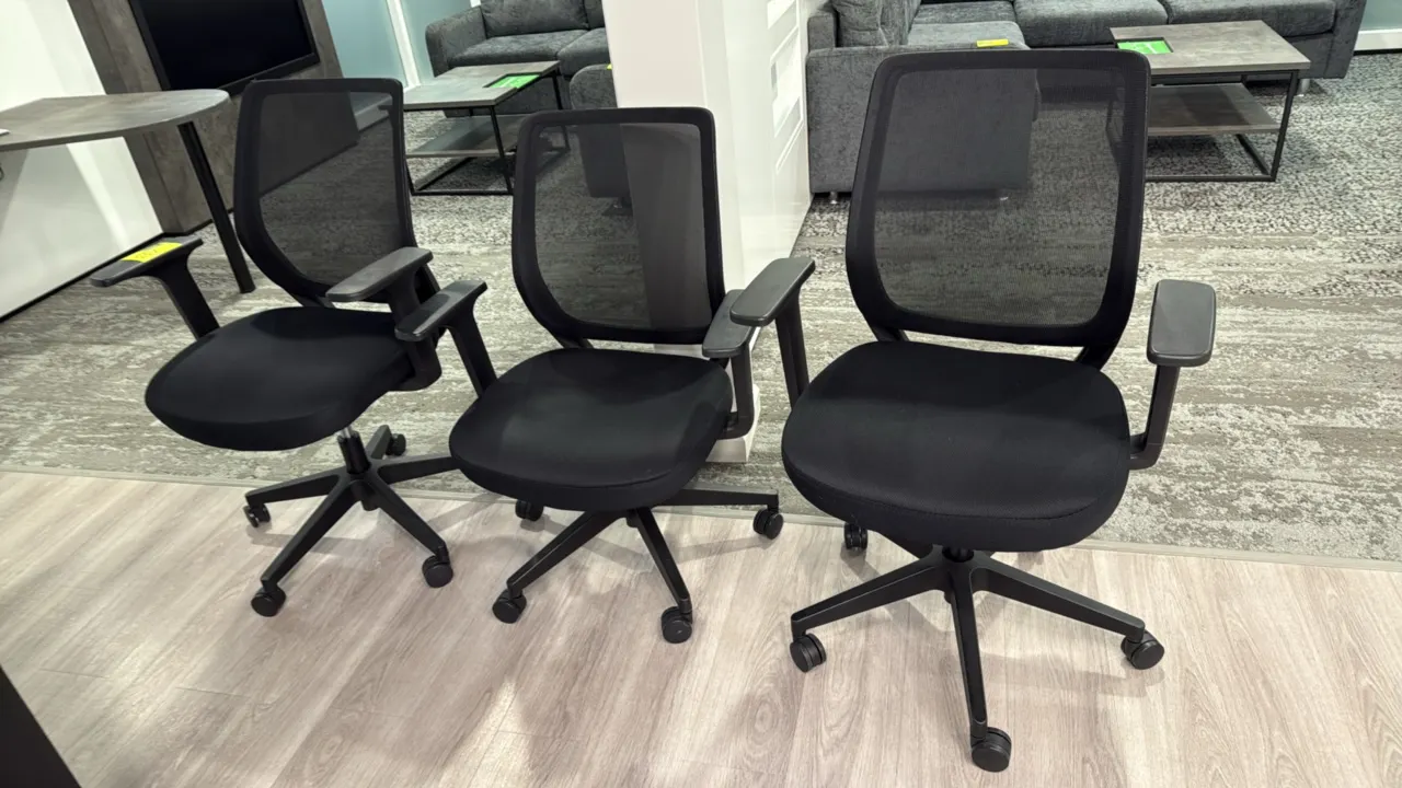Rolling mesh-back office chairs. Features black mesh backrests, upholstered fabric seats, armrests, and adjustable seat height. Mounted on 5-star base