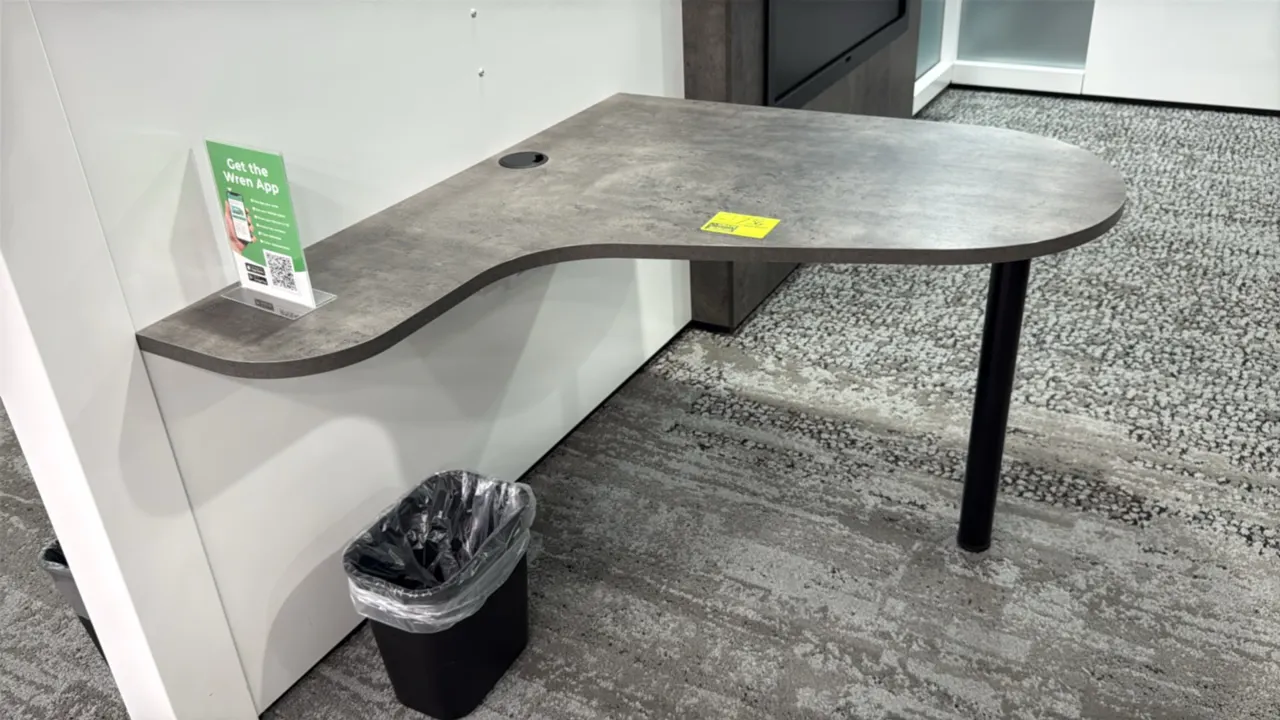 Laminate wall-mounted desks. Features contoured stone-look laminate work surfaces and integrated cable pass-through grommets. 42". Supported by single