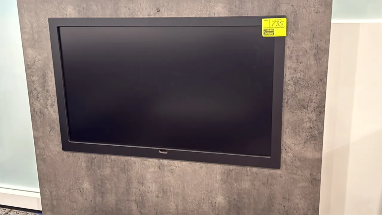 Samsung 50" flat screen color display monitor. Features a black bezel. Wall-mounted. Mounting panel not included.