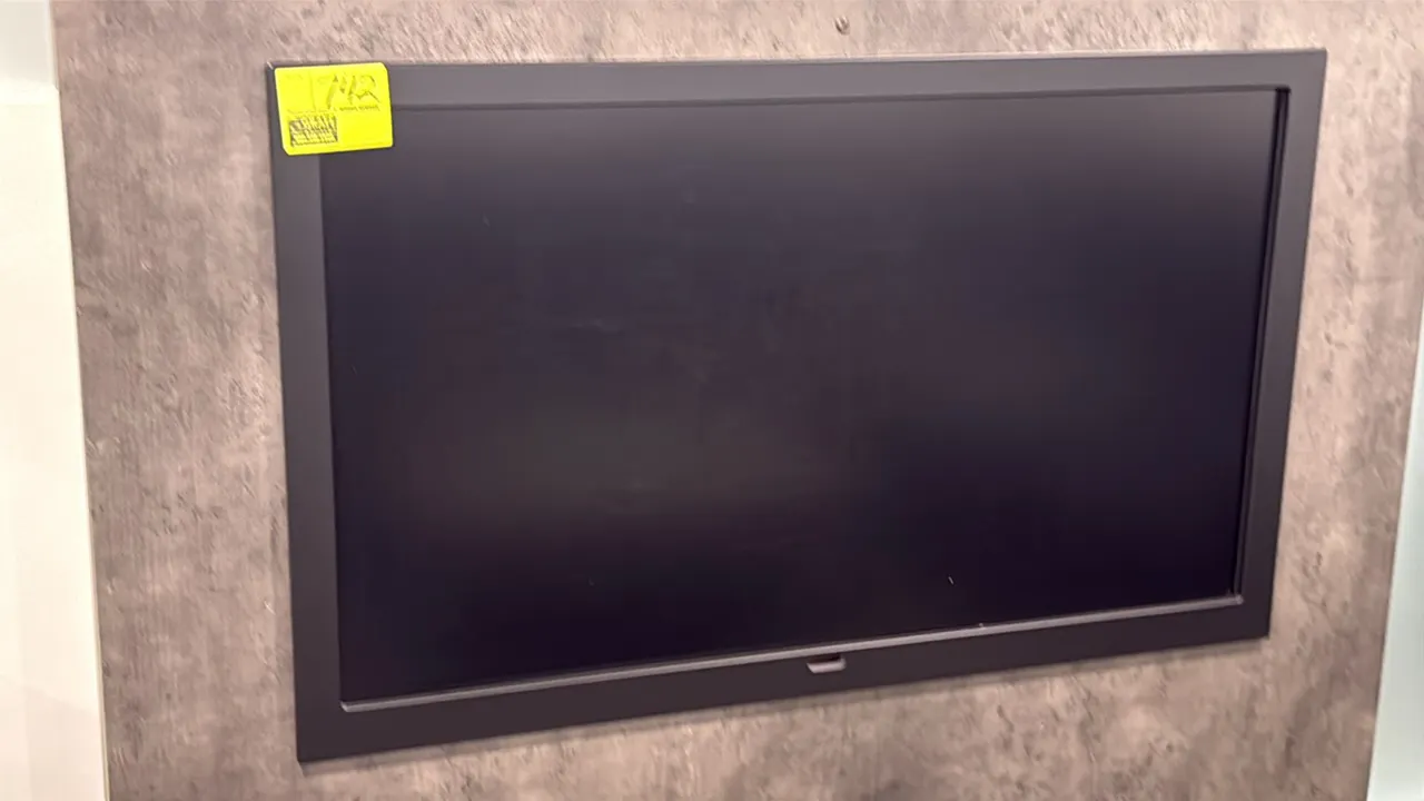 Samsung 50" flat screen color display monitor. Features a black frame bezel. Wall-mounted. Wall panel not included.