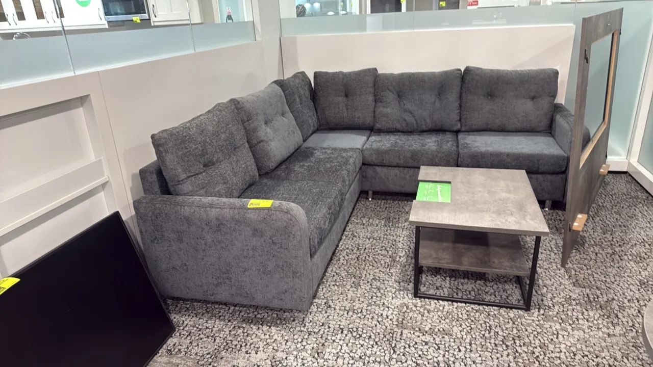 L-shaped sectional couch with coffee table. Couch features gray textured fabric upholstery, tufted back cushions, and metal legs; measures 87" x 59".