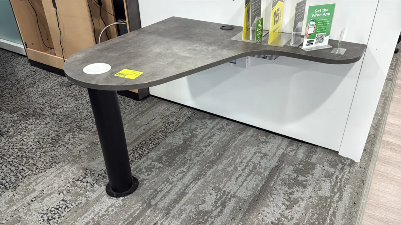 Laminate wall-mounted desks. Features contoured gray laminate work surfaces, cable pass-through grommets, and single black post support legs. 42". IT