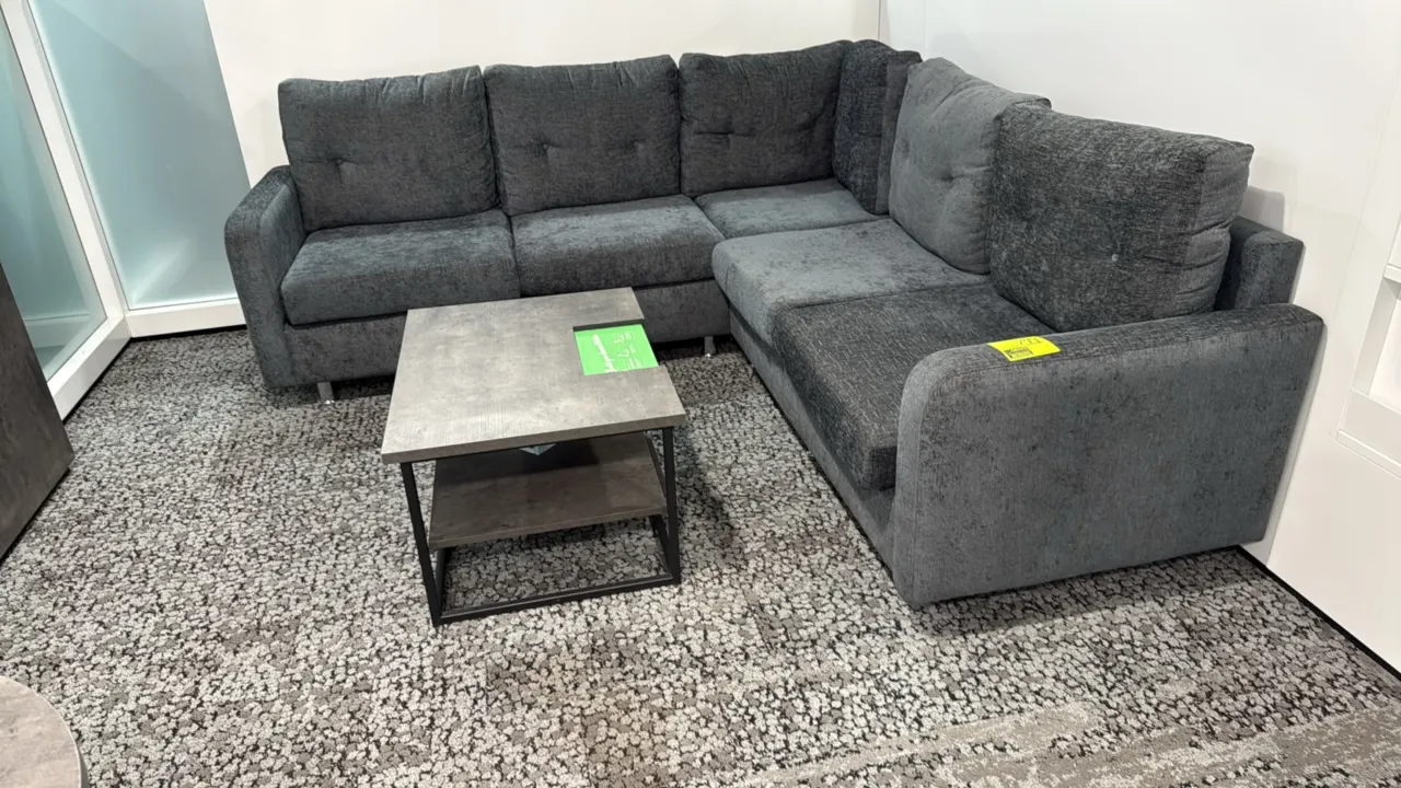 L-shaped sectional sofa with coffee table. Couch features charcoal gray textured fabric upholstery, tufted back cushions, and metal legs; 87" x 59". I
