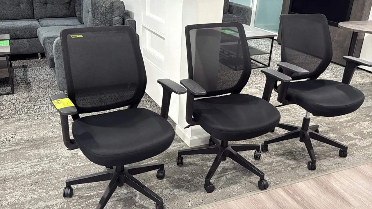 Rolling mesh-back office chairs. Features breathable black mesh backrests, black upholstered fabric seats, armrests, and pneumatic seat-height adjustm
