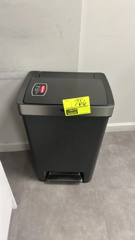 Rubbermaid Premier step-on trash can. Features hands-free foot pedal operation, hinged lid, accent trim, and charcoal plastic construction. Designed t