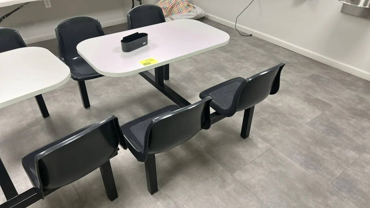 Laminate 4-person break room table. Features a white laminate tabletop with rounded corners, (4) attached black molded plastic seats, and a black meta