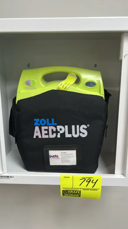 ZOLL AED Plus automated external defibrillator. Includes branded soft carrying case and white metal wall-mount storage cabinet with viewing window.