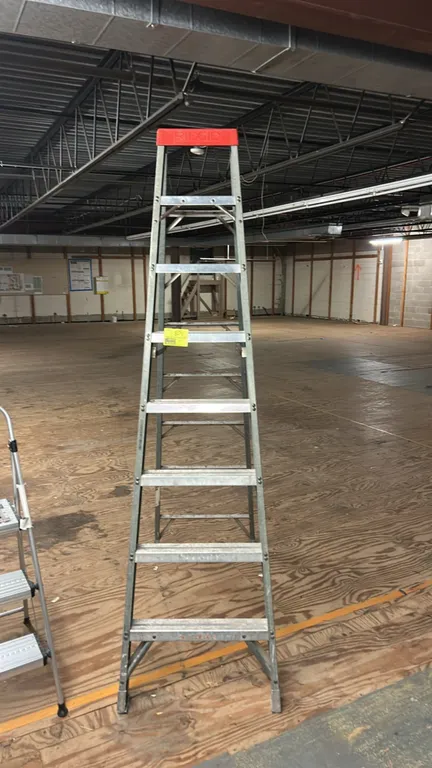 Ridgid 8' aluminum stepladder. Features a red molded top cap, slip-resistant steps, and folding spreader braces.