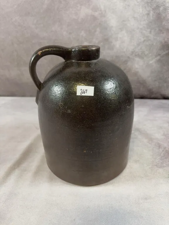 (1) Gallon Dark Brown "Orange Peel" Jug. Possible Donaggho or RRP. Very good condition. Small chip on handle. Circa 1870-1890