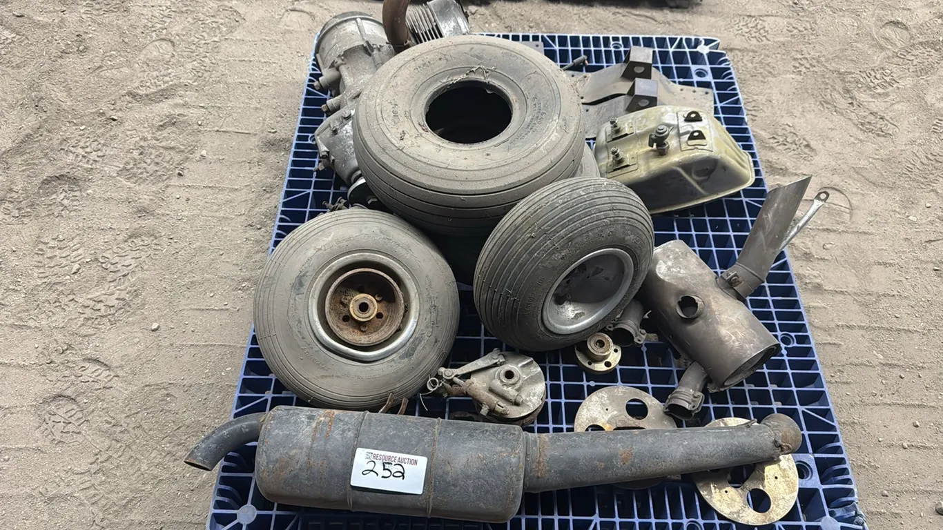 Assorted airplane parts including small engine, wheels & exhaust