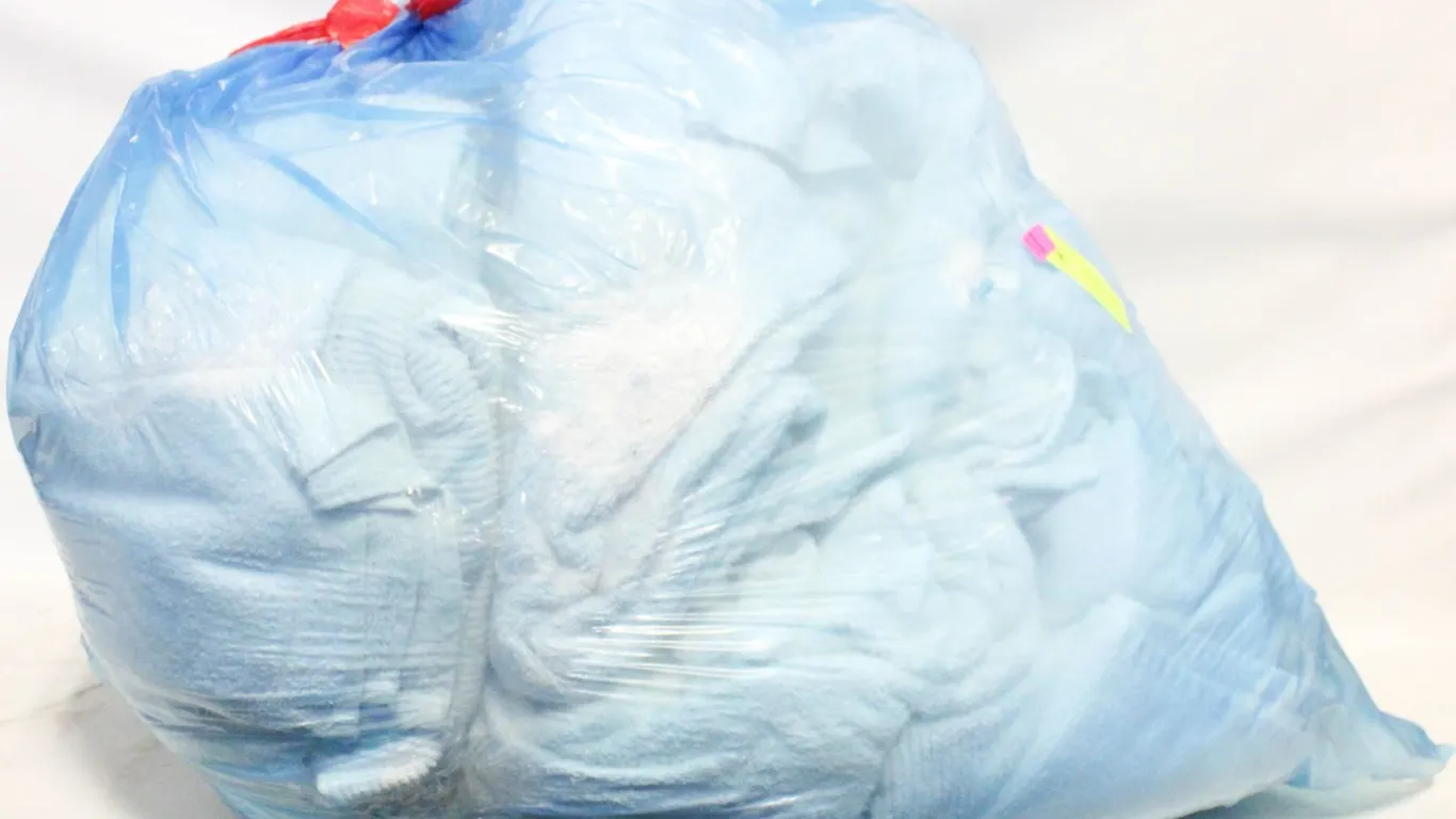 LARGE CLEAR BAG FULL OF WHITE TOWELS