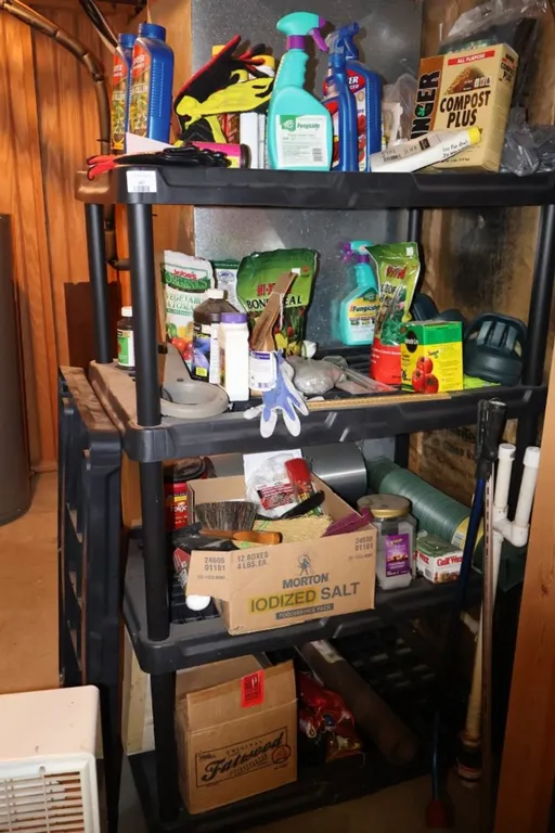 Four-Tier Black Plastic Utility Shelf with Assorted Gardening Supplies and Household Items