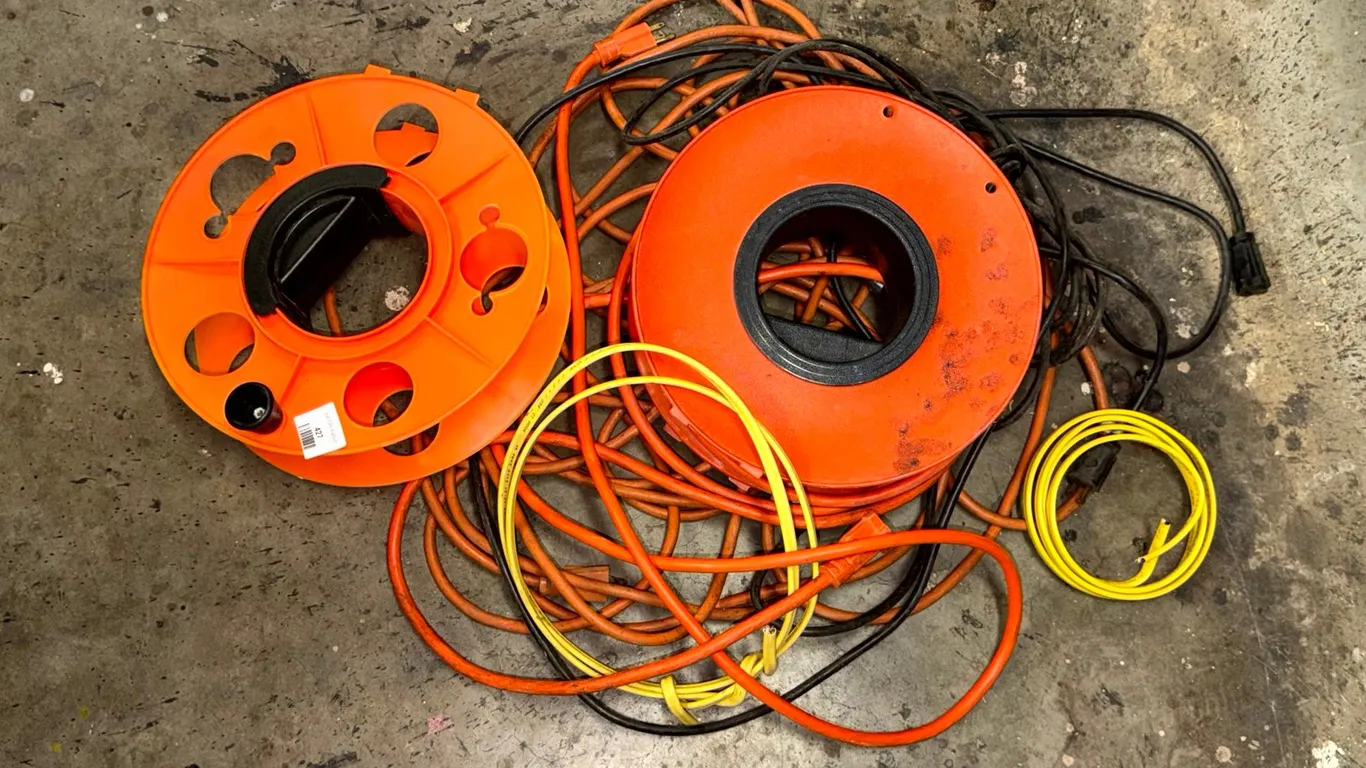 Two Orange Plastic Cord Storage Reels and Extension Cords