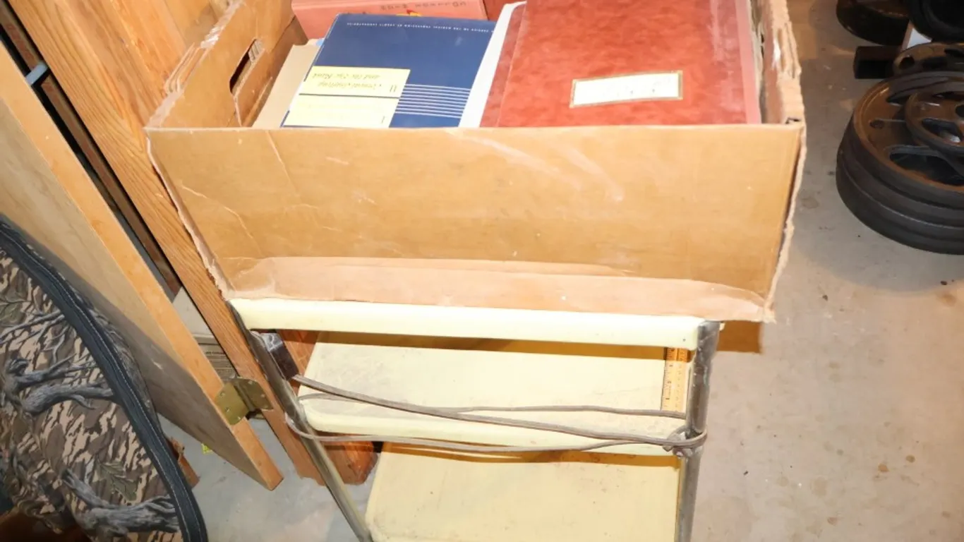 Three-Tier Metal Rolling Utility Cart with Assorted Medical Binders, Booklets, and Yearbook