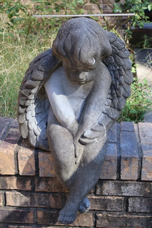 Cast Concrete Seated Winged Cherub Statue and Cast Stone Owl Garden Sculpture