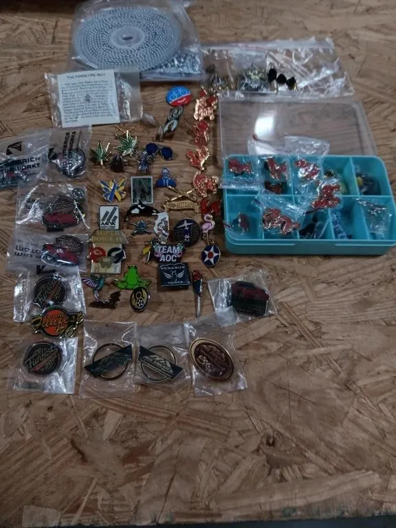 Assortment of lapel pins & spool of beads.