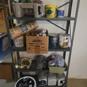 Assorted painting supplies and metal shelving unit