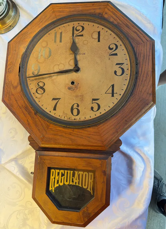 An early 20th-century E Ingraham oak schoolhouse drop regulator wall clock