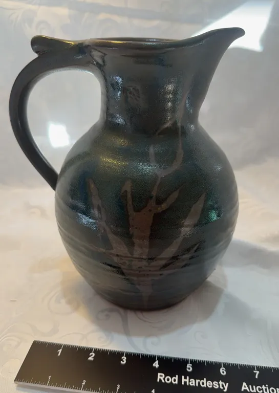 Handmade art pottery pitcher with a dark/metallic glaze
