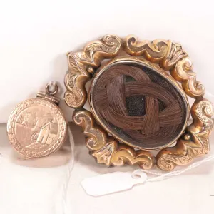 Two pieces of antique Victorian mourning jewellery including rolled gold brooch with braided dark ha