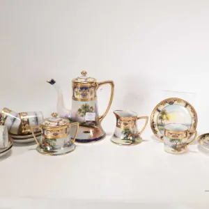 Antique hand-painted Noritake coffee service with scenic landscape panels and heavy gold gilding. In