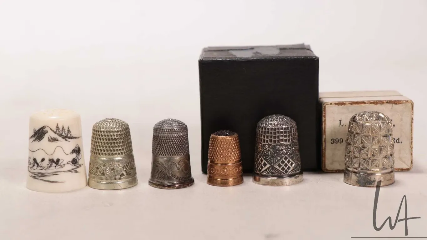 Six collectible thimbles including Inuit carved scrimshaw featuring a dog sled team, two boxed sterl