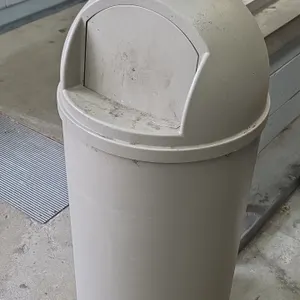 Rubbermaid trash can. Features molded plastic construction and a dome-top swing-door lid. Finished in beige. 42"H.