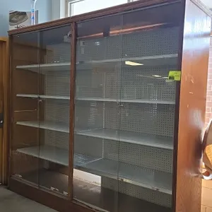 Wood frame display case with sliding glass doors. Features pegboard backing, adjustable solid metal shelving, sliding glass doors with locks and keys,