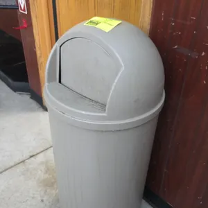 Rubbermaid trash can with lid. Features molded plastic construction and a dome-top swing flap lid. 42"H.