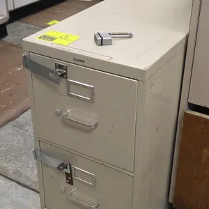 HON 2-drawer vertical filing cabinet. Features metal construction in putty finish, label holders, drawer pull handles, and exterior locking hasps. Inc