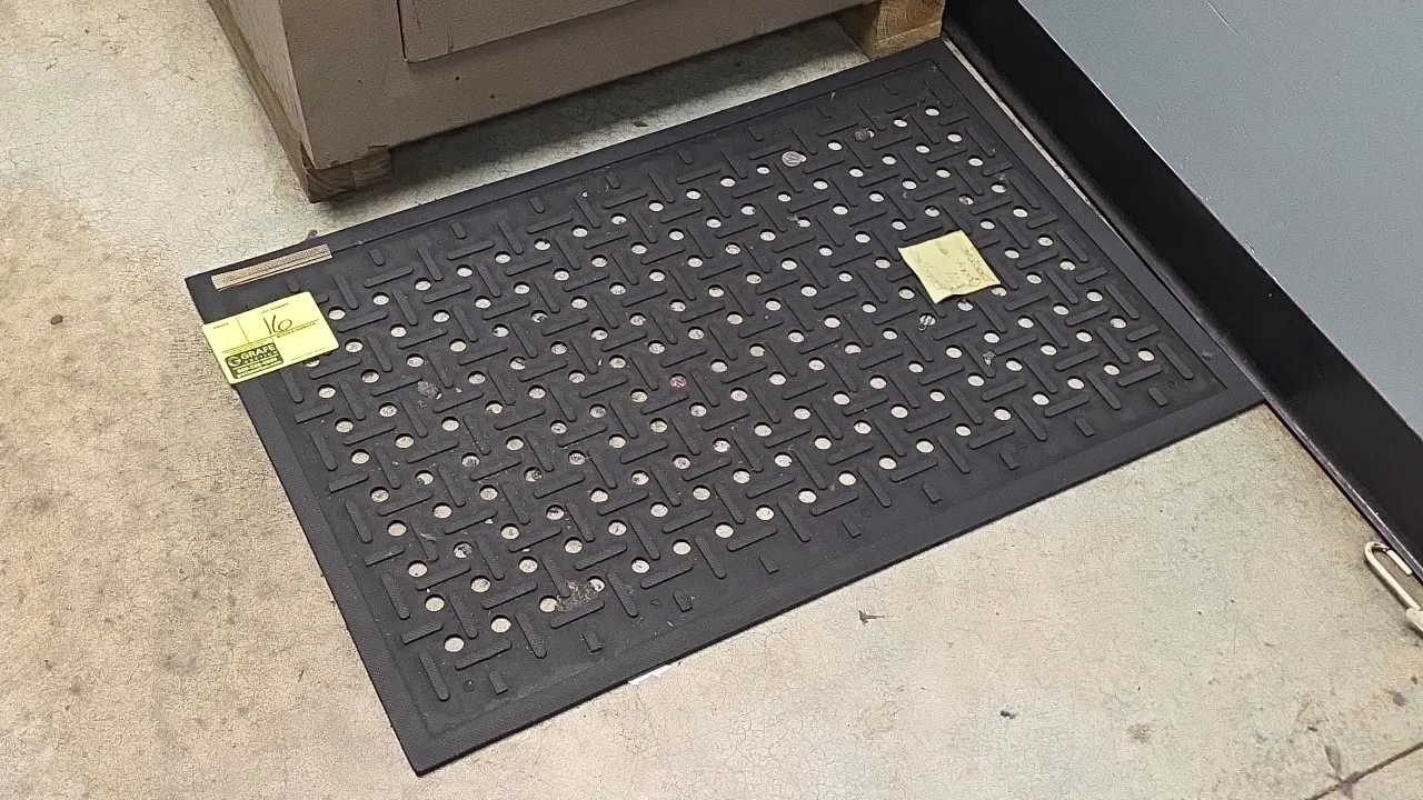 Rubber floor mat. Features perforated drainage holes, textured non-slip tread, and beveled safety edges. 36" x 24".