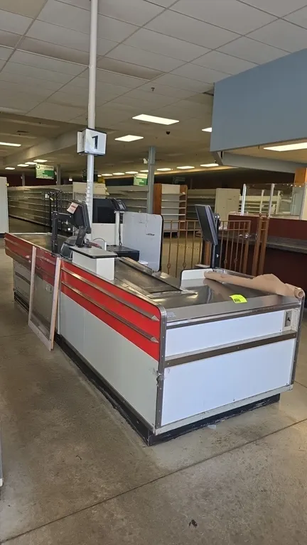 Borroughs Series 80 dual belt checklane. Features motorized front and rear conveyor belts, integrated scanner well, lane number light pole, cashier st