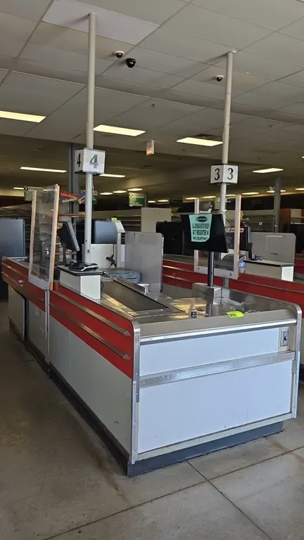 Borroughs Series 80 dual belt checklane. Features stainless steel trim, dual conveyor belts, acrylic protective shield, lane light pole, and lower sto