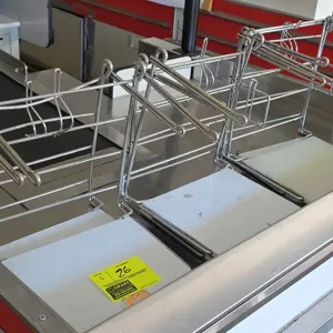 Metal poly bag stands. Features chrome-plated wire construction with dual bag hanging arms and polyethylene base plates. Note: Checkout counter not in