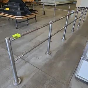 Metal L-shape cart rails. Features tubular dual-rail construction and upright posts. Dimensions: 18' x 15'. Floor flange mounted.