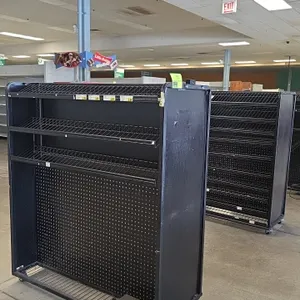 Portable metal candy and magazine merchandisers. Features black metal frames, slanted wire display shelves, lower pegboard display panels, and bottom 