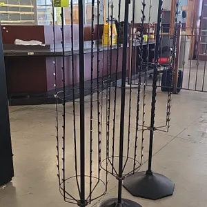 Metal rotating clip merchandisers. Features rotating wire racks with hanging display clips for bagged goods and packaged merchandise. 64"H. Mounted on