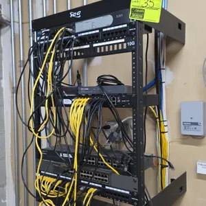 ICC wall-mount open-frame IT rack with contents. Includes network switches (3Com, Ubiquiti EdgeSwitch, TP-Link, TRENDnet, and D-Link), patch panels, a