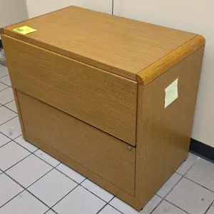 Laminate 2-drawer lateral file cabinet. Features an oak woodgrain finish, rounded front edge trim, integrated drawer pulls, and lower drawer lock. 36"