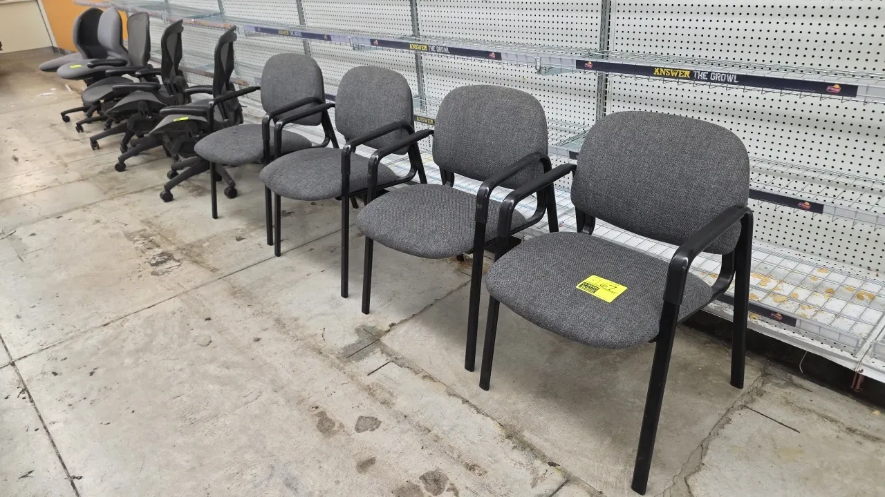Cushioned metal frame office chairs. Features gray fabric upholstered seat and backrest, black molded armrests, and black back shroud. Mounted on a st