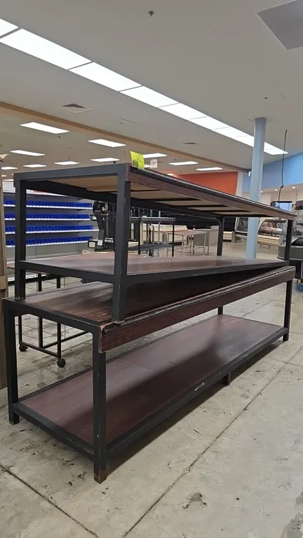 2-tier produce display tables. Features woodgrain laminate shelving, wood-look trim, and black metal frame construction. 120"L.