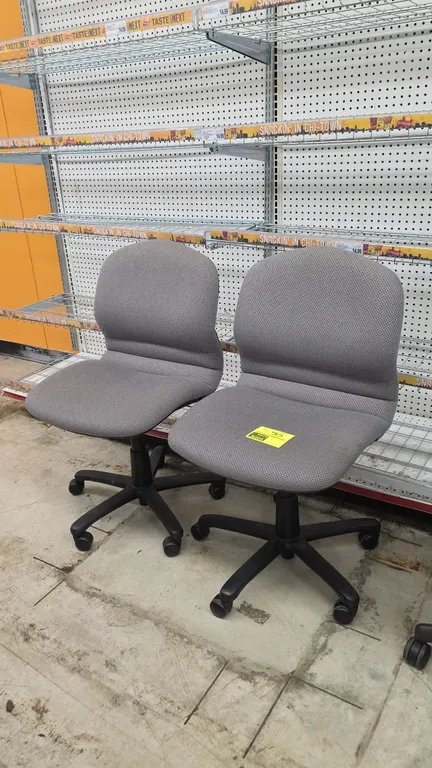Cushioned adjustable armless office chairs. Features gray patterned fabric upholstery, contoured seat and backrest, and pneumatic height adjustment. M