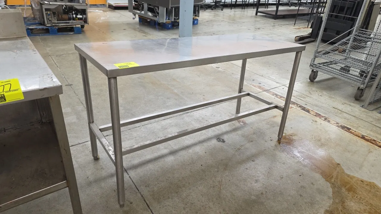 Stainless steel work table. Features a flat top work surface and lower tubular cross-bracing. 60"L. Mounted on tubular legs with adjustable bullet fee