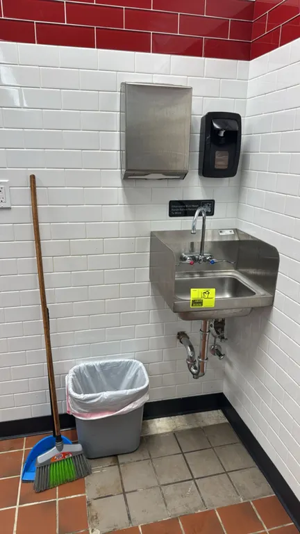 John Boos stainless steel hand sink. Features side splash guards and splash-mount gooseneck faucet with wrist blade handles. Includes wall-mounted sta
