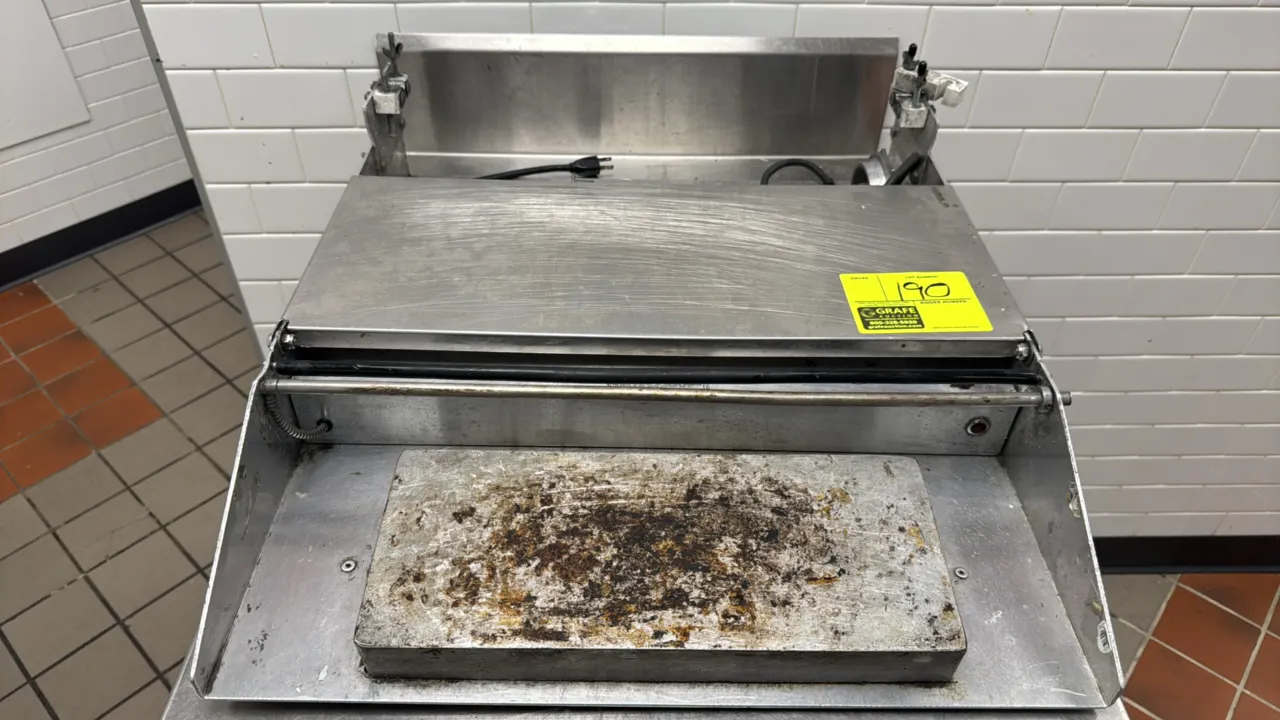 Heat Seal single-roll tabletop film wrapper. Features stainless steel and aluminum construction, heated cutoff rod, front heated seal plate, and film