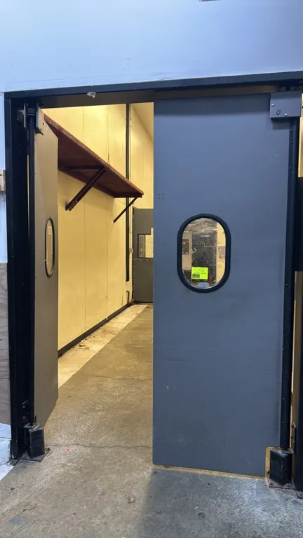 Mueller poly swing doors. Features gray polyethylene construction, oval vision windows, double-acting swing operation, and hinge mounting hardware. Me