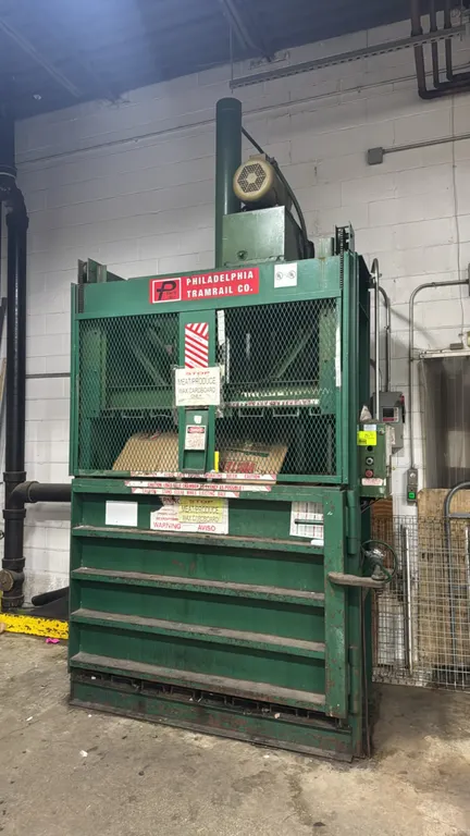 1999 PTR 2300HDLH vertical baler. Features right-side handwheel screw lock, wire mesh safety gate, and top-mounted hydraulic drive. 60"W. S/N: 9876467