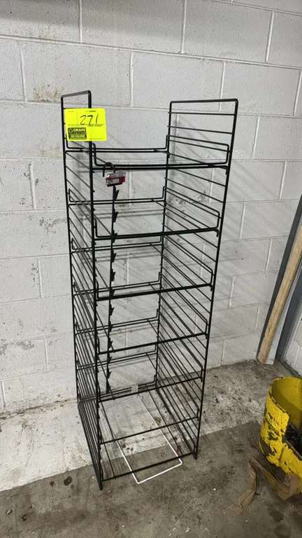 Metal multi-tier wire merchandiser display rack. Features multi-level wire shelving and an attached hanging merchandise clip strip. Black finish. 16"