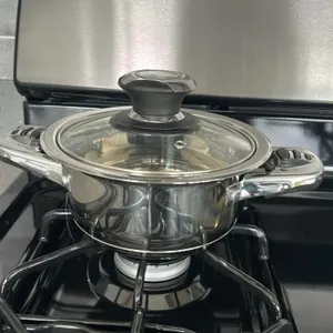 Assorted kitchen smallwares. Includes ceramic dinnerware (plates, bowls, mugs), flatware, placemats, stainless steel pot with glass lid, wire mug tree