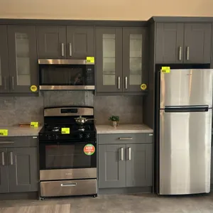 Infinity Plus laminate kitchen cabinets with laminate countertops. Features dark gray shaker-style doors, frosted glass upper inserts, metal bar pulls
